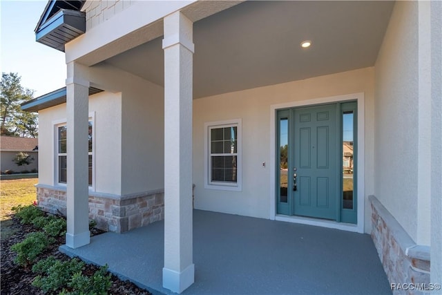 doorway to property featuring stone siding and stucco siding