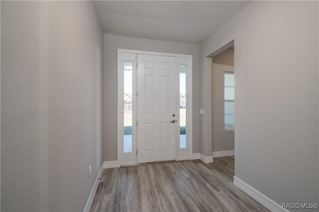 foyer featuring wood finished floors and baseboards