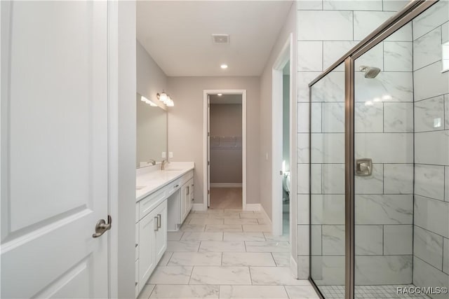 full bathroom with double vanity, marble finish floor, a shower stall, and baseboards