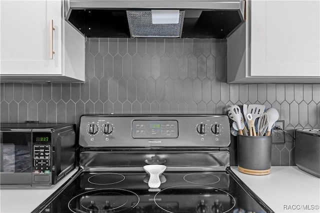 interior details with backsplash, white cabinetry, and black appliances