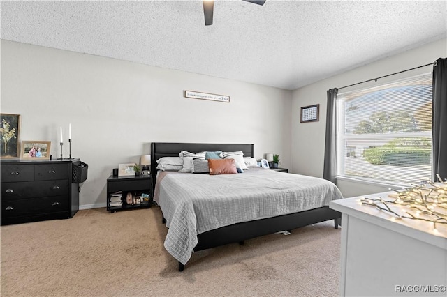 carpeted bedroom featuring ceiling fan and a textured ceiling