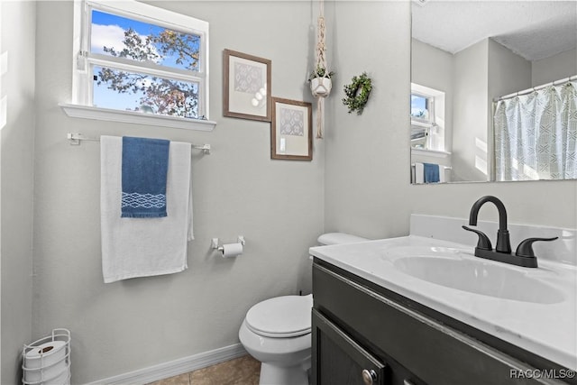 bathroom with tile patterned flooring, vanity, and toilet