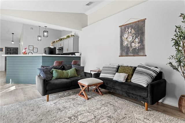 living room with light hardwood / wood-style flooring and lofted ceiling