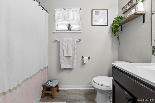 bathroom featuring wood-type flooring, vanity, and toilet