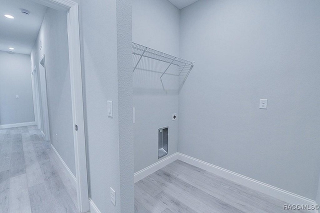 laundry area with hookup for an electric dryer and light hardwood / wood-style floors