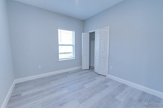 unfurnished bedroom featuring light hardwood / wood-style floors and a closet