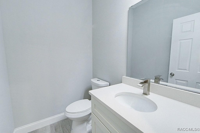 bathroom featuring vanity, toilet, and wood-type flooring