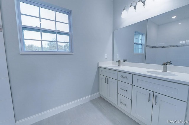 bathroom featuring tile patterned floors, vanity, a healthy amount of sunlight, and tiled shower