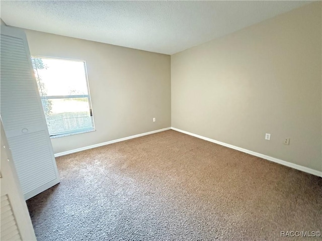 carpeted spare room with a textured ceiling