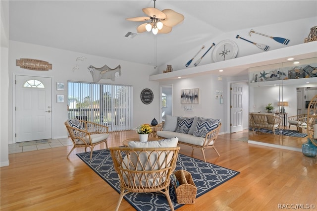 living room with ceiling fan, light hardwood / wood-style floors, and high vaulted ceiling