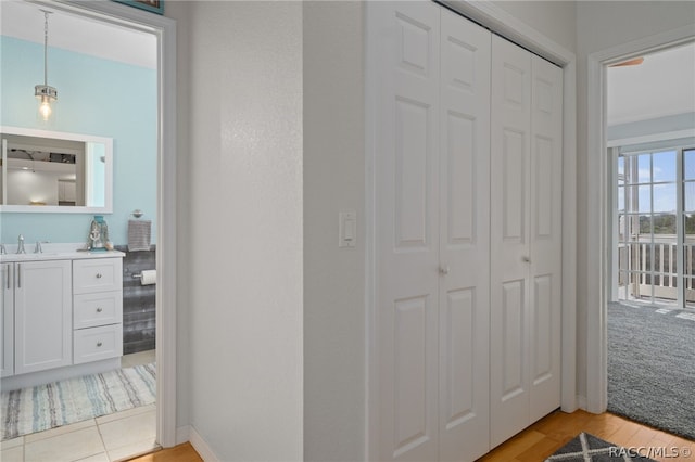 hall with light hardwood / wood-style floors and sink