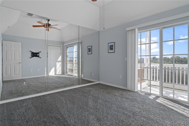 carpeted empty room with vaulted ceiling, plenty of natural light, and ceiling fan