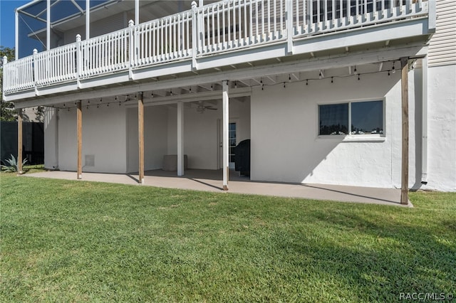 back of house with a lawn, ceiling fan, a patio area, and a balcony