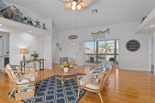 living room featuring ceiling fan, high vaulted ceiling, and light hardwood / wood-style floors