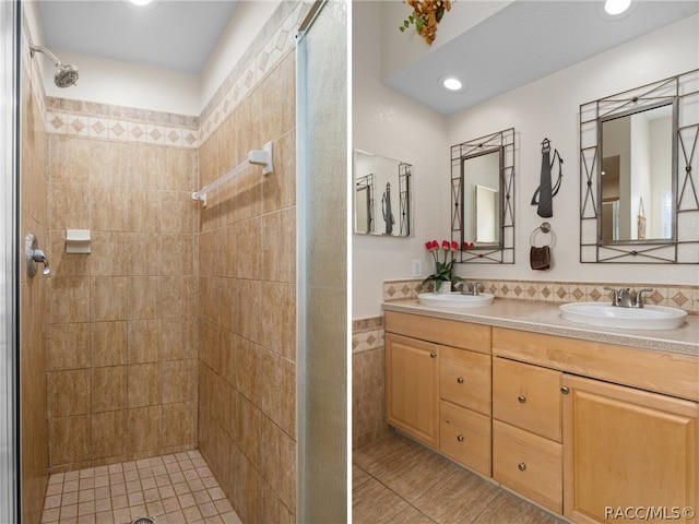 bathroom featuring a tile shower, tile patterned floors, vanity, and tile walls