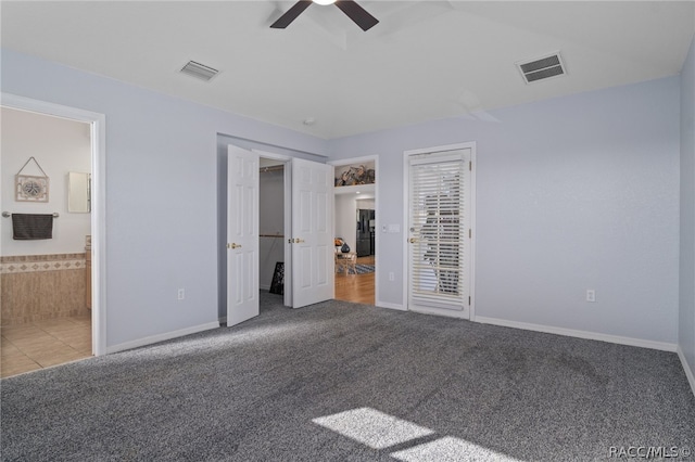 unfurnished bedroom featuring connected bathroom, carpet floors, and ceiling fan