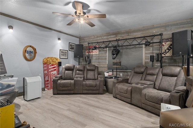 cinema room with ceiling fan, ornamental molding, and hardwood / wood-style flooring