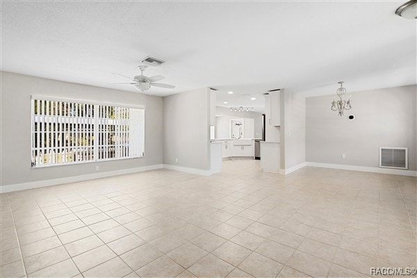 3929 N Sagomon Pt, Crystal River, FL 34428 - unfurnished living room with light tile patterned flooring, a ceiling fan, a chandelier, and recessed lighting