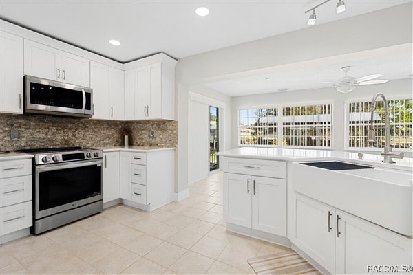 3929 N Sagomon Pt, Crystal River, FL 34428 - kitchen with appliances with stainless steel finishes, backsplash, plenty of natural light, white cabinets, and recessed lighting