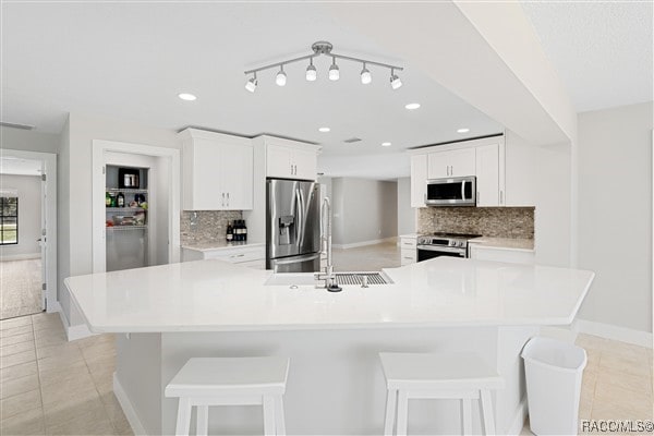 3929 N Sagomon Pt, Crystal River, FL 34428 - kitchen with appliances with stainless steel finishes, light tile patterned floors, decorative backsplash, light countertops, and recessed lighting