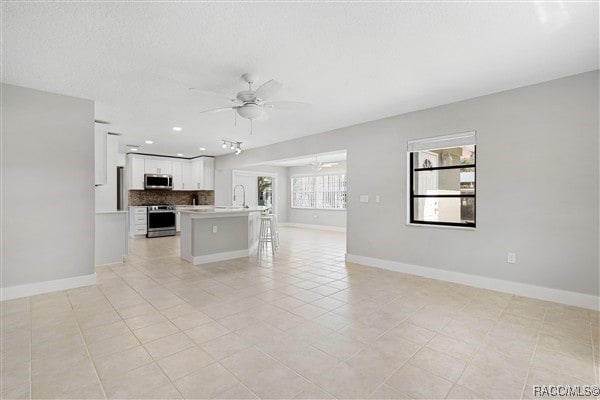 3929 N Sagomon Pt, Crystal River, FL 34428 - unfurnished living room featuring a ceiling fan, recessed lighting, and light tile patterned flooring