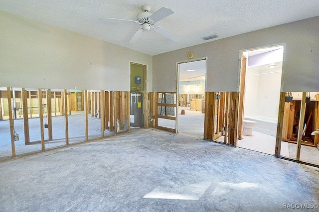 unfurnished room with ceiling fan, electric water heater, and a textured ceiling