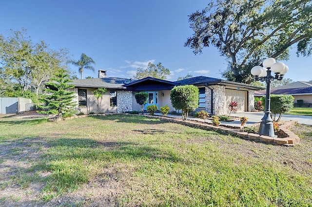 view of front of property featuring a garage and a front lawn