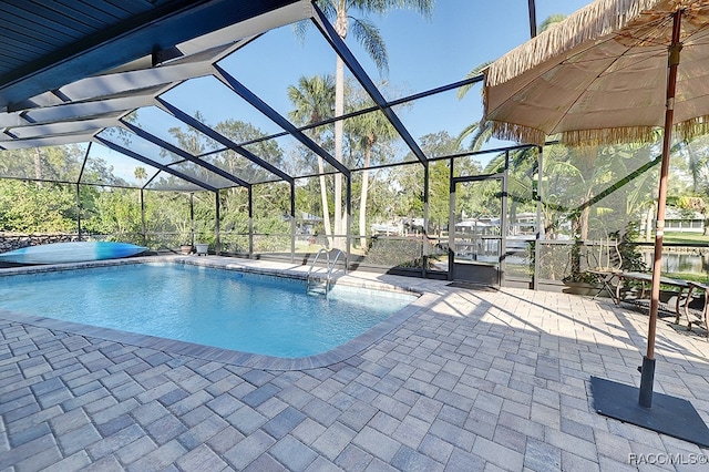 view of swimming pool with glass enclosure and a patio