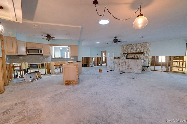 unfurnished living room with ceiling fan, a fireplace, and light carpet