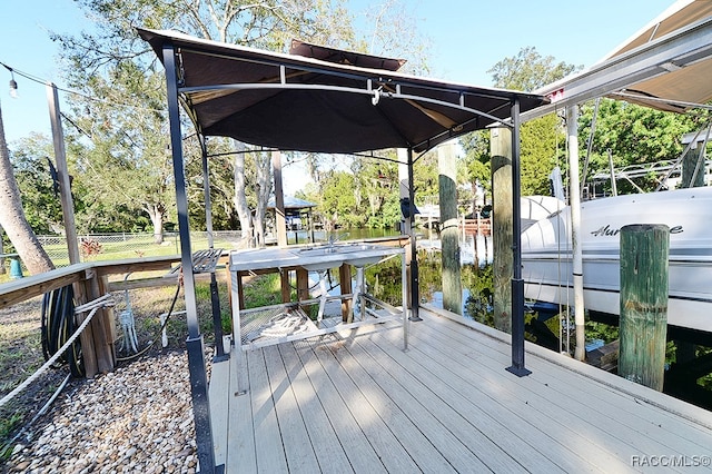 wooden terrace with a boat dock and a water view