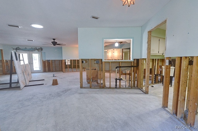 misc room featuring ceiling fan and wood walls