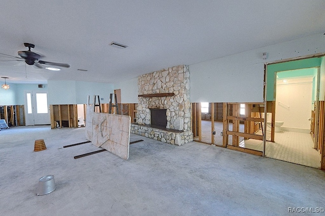 living room featuring a fireplace, light colored carpet, and ceiling fan