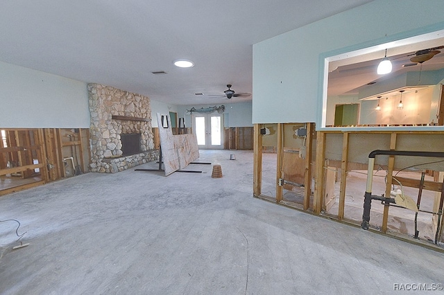 living room with carpet flooring, a stone fireplace, ceiling fan, and french doors