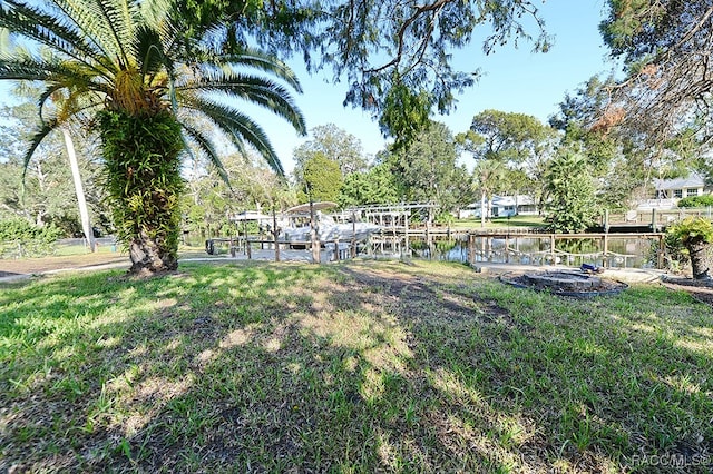 view of yard featuring a water view and a dock