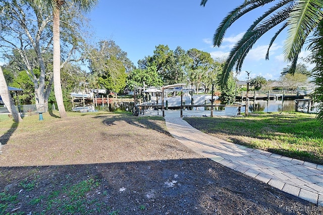 view of yard featuring a water view and a dock