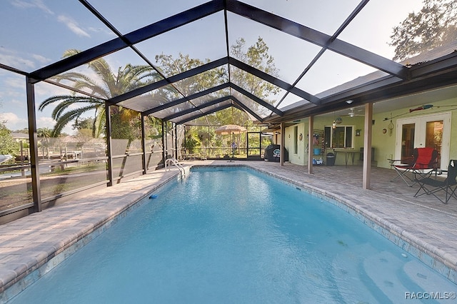 view of swimming pool featuring glass enclosure, ceiling fan, a patio, and french doors