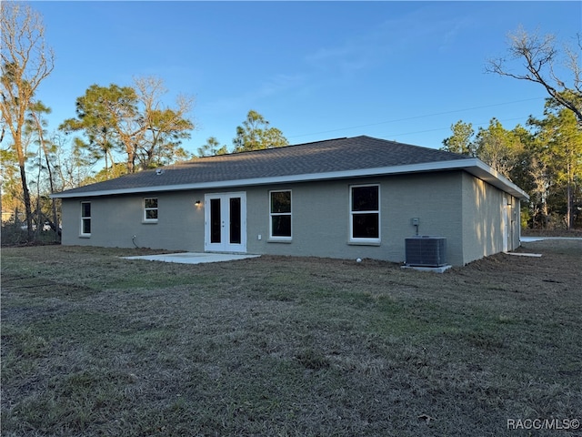 back of property featuring french doors, a yard, a shingled roof, a patio area, and cooling unit