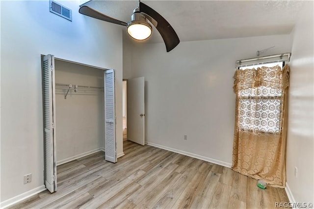 unfurnished bedroom featuring light wood-type flooring, a closet, ceiling fan, and lofted ceiling