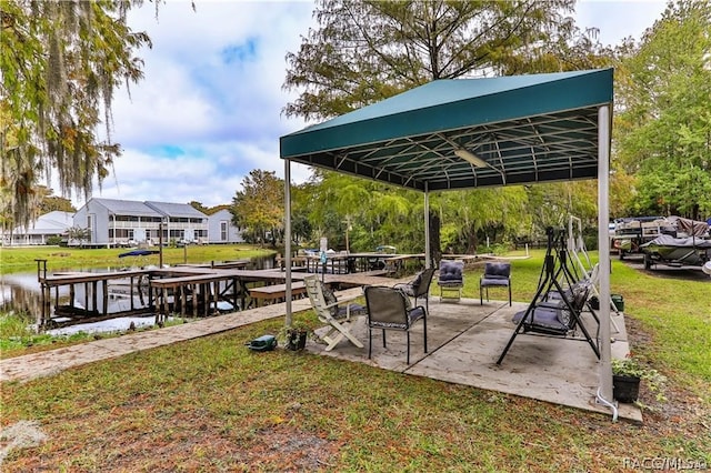 exterior space with a gazebo, a boat dock, a water view, and a yard