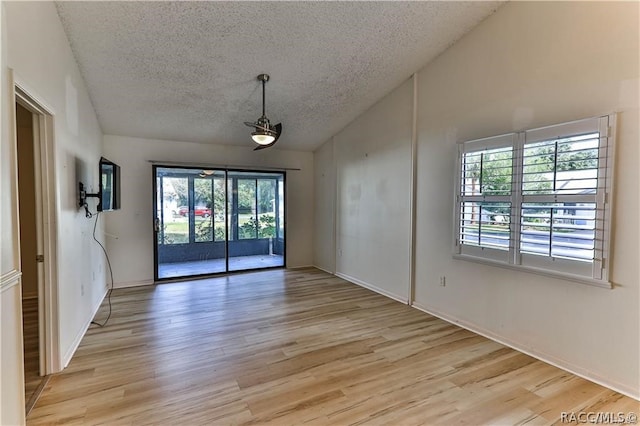 spare room with light hardwood / wood-style floors and a textured ceiling