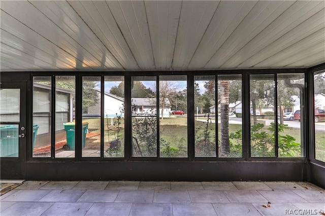 unfurnished sunroom featuring wood ceiling and a wealth of natural light