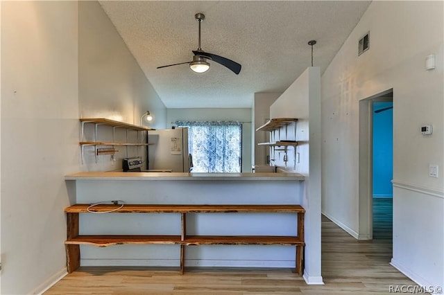 kitchen featuring a textured ceiling, white fridge, light hardwood / wood-style flooring, and ceiling fan