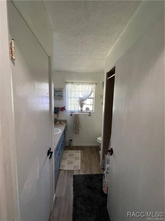 9445 W Milwaukee Ct, Crystal River, FL 34428 - bathroom with toilet, wood finished floors, a textured ceiling, and vanity