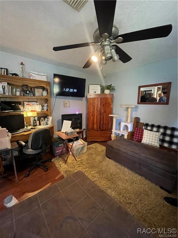 9445 W Milwaukee Ct, Crystal River, FL 34428 - tiled home office with ceiling fan and a textured ceiling