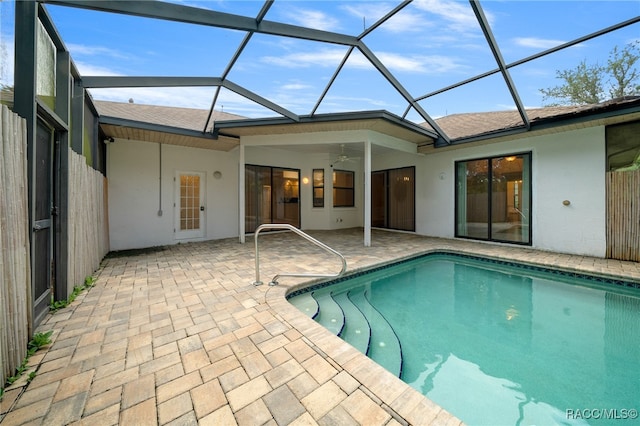 view of swimming pool with ceiling fan, a lanai, and a patio