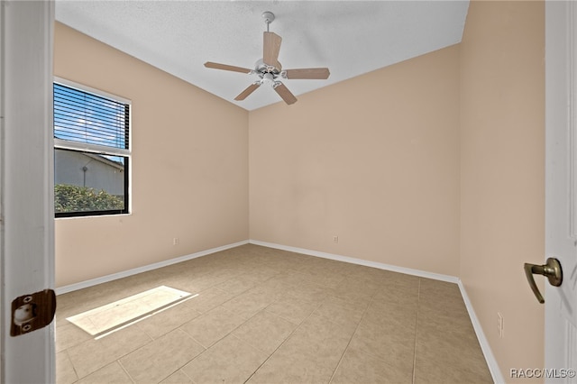 tiled spare room featuring a textured ceiling and ceiling fan