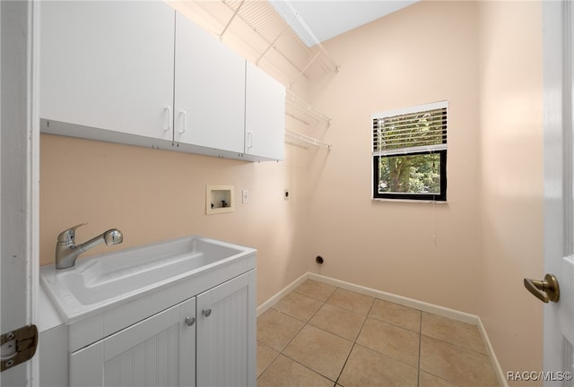 washroom featuring sink, cabinets, hookup for an electric dryer, hookup for a washing machine, and light tile patterned flooring