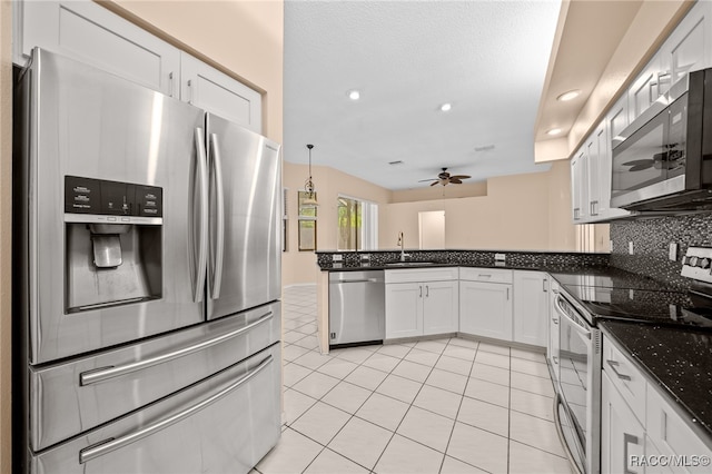 kitchen with pendant lighting, backsplash, ceiling fan, white cabinetry, and stainless steel appliances