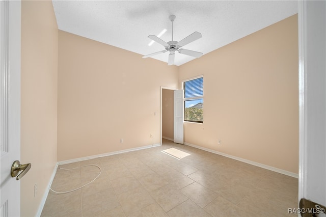 tiled spare room featuring a textured ceiling and ceiling fan