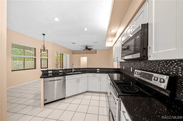 kitchen with white cabinets, decorative light fixtures, sink, and stainless steel appliances